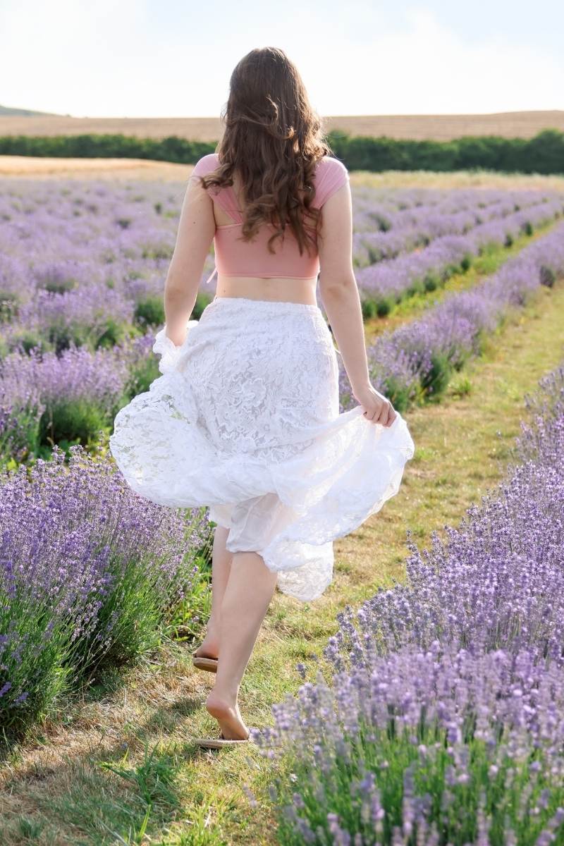 geluk zit in kleine momenten vrouw geniet van lavendel veld vol bloeiende lavendel